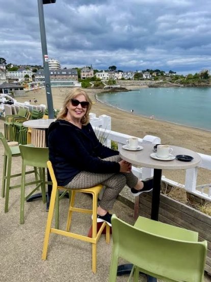 Domweg gelukkig op een kruk aan zee.