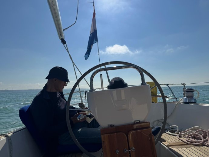 Zon, kalme zee, hoedje en boek onderweg.